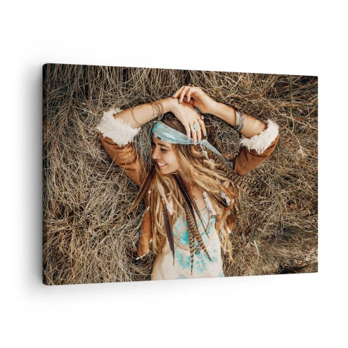 Obraz na płótnie - Kobieta w stylu boho leżąca na sianie - 70x50cm - W drodze do lata miłości - Nowoczesna dekoracja ścienna do salonu i sypialni ARTTOR