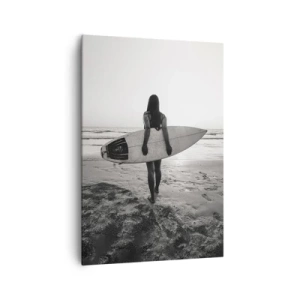 Obraz na płótnie - Kobieta z deską surfingową na plaży w czerni i bieli - 70x100cm - Córka morskiej fali - Nowoczesna dekoracja ścienna do salonu i sypialni ARTTOR