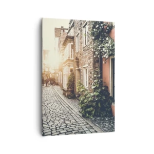 Obraz na płótnie - Urokliwa uliczka z kamiennym brukiem i kwiatami - 70x100cm - Różany zaułek w różowym blasku - Nowoczesna dekoracja ścienna do salonu i sypialni ARTTOR