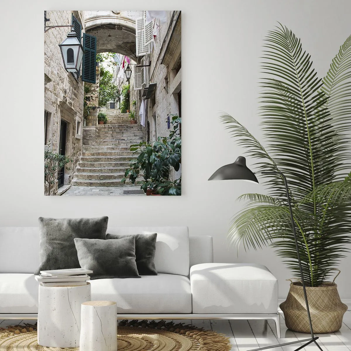 Obraz na szkle - Kamienna uliczka z roślinami i łukiem między budynkami - 70x100cm - Urokliwy zaułek - Nowoczesna dekoracja ścienna do salonu i sypialni ARTTOR