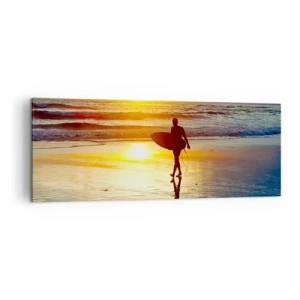 Obraz na płótnie - Surfer idący po plaży o zachodzie słońca z deską w ręku - 140x50cm - Powrót wojownika - Nowoczesna dekoracja ścienna do salonu i sypialni ARTTOR