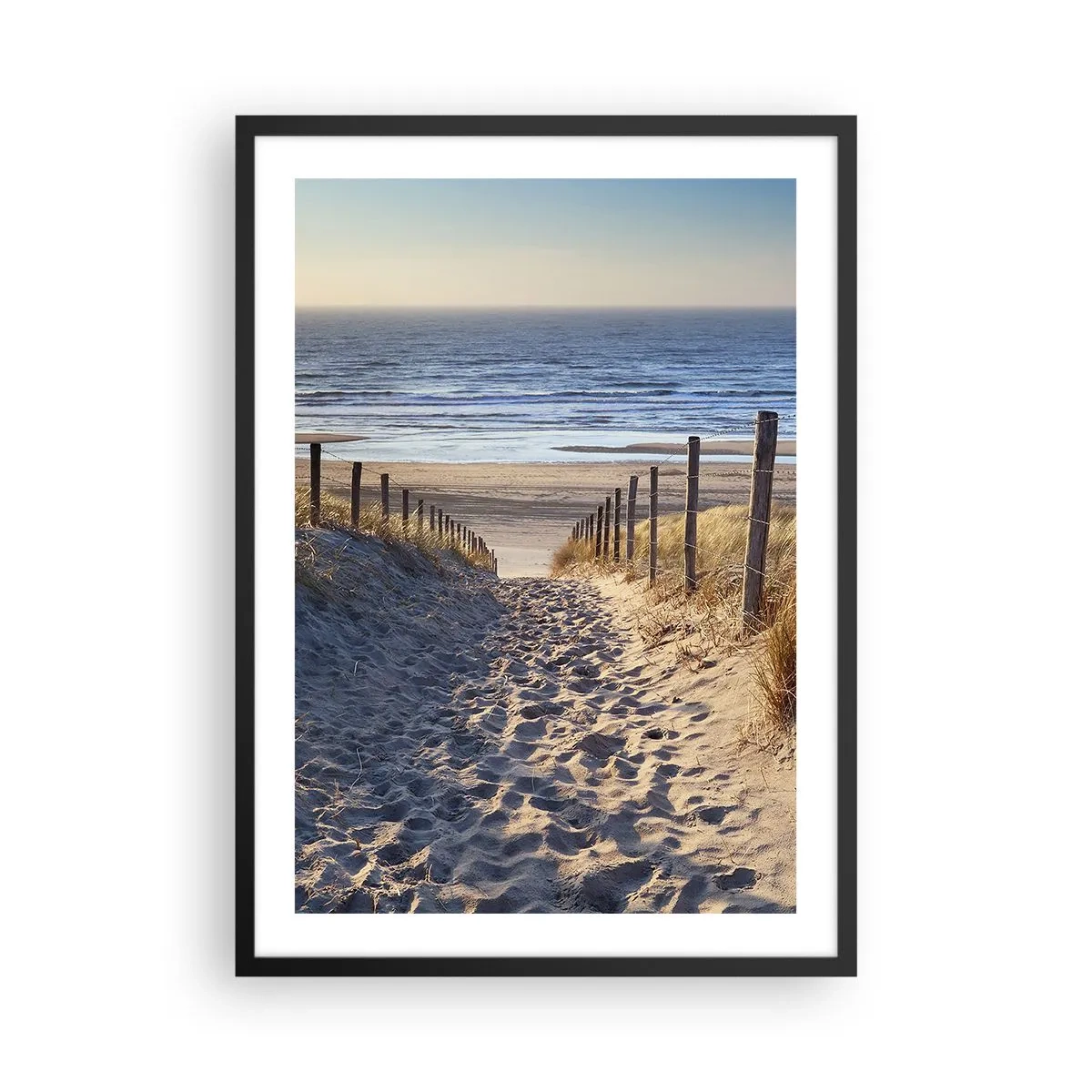 Plakat w czarnej ramie - Ścieżka przez wydmy prowadząca na plażę przy zachodzie słońca - 50x70cm - Morza szum, ptaków śpiew, dzika plaża pośród traw… - Nowoczesna dekoracja ścienna do salonu i sypialni ARTTOR