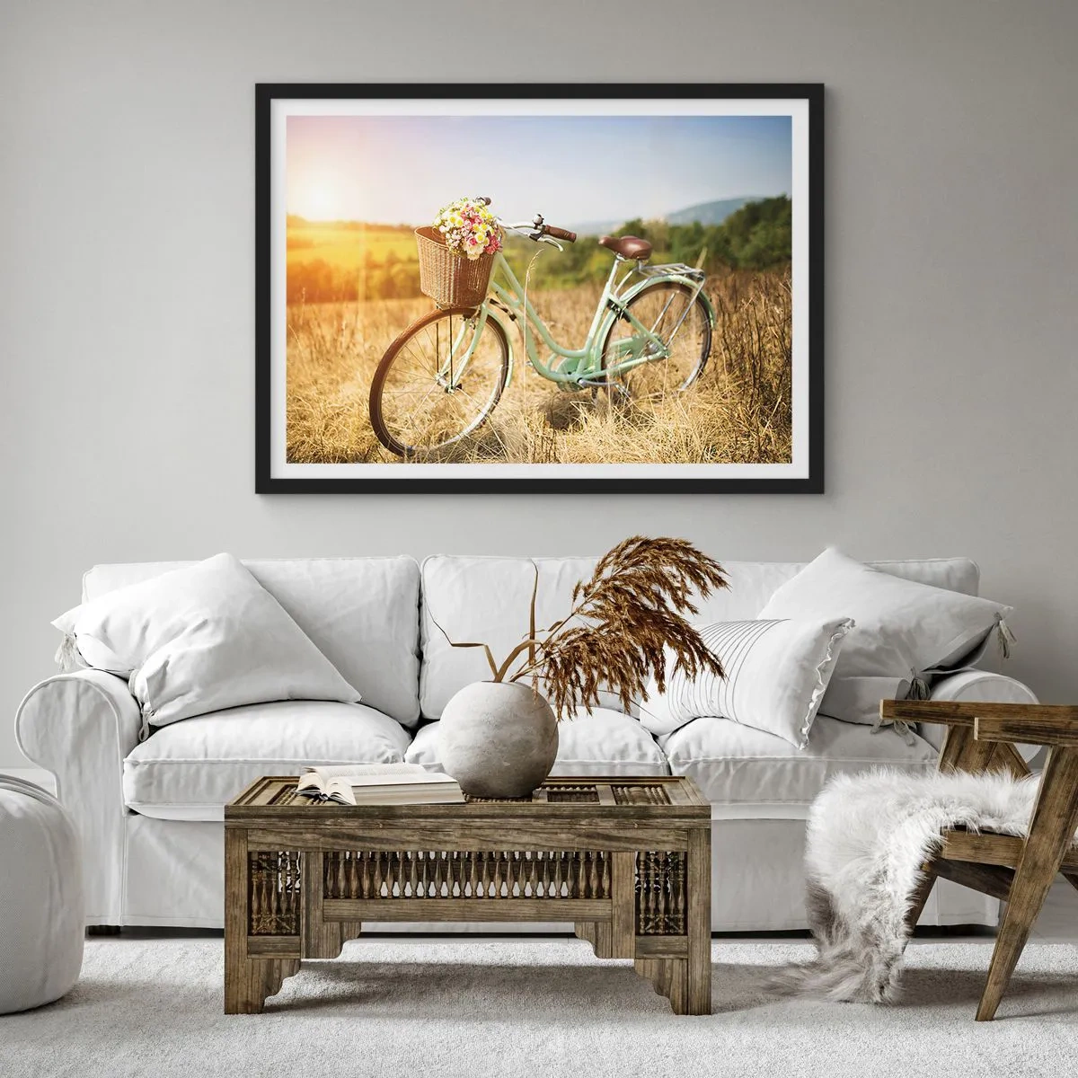Plakat w czarnej ramie - Retro rower z koszykiem pełnym kwiatów na tle łąki - 70x50cm - Zostanę tu chwilę - Nowoczesna dekoracja ścienna do salonu i sypialni ARTTOR