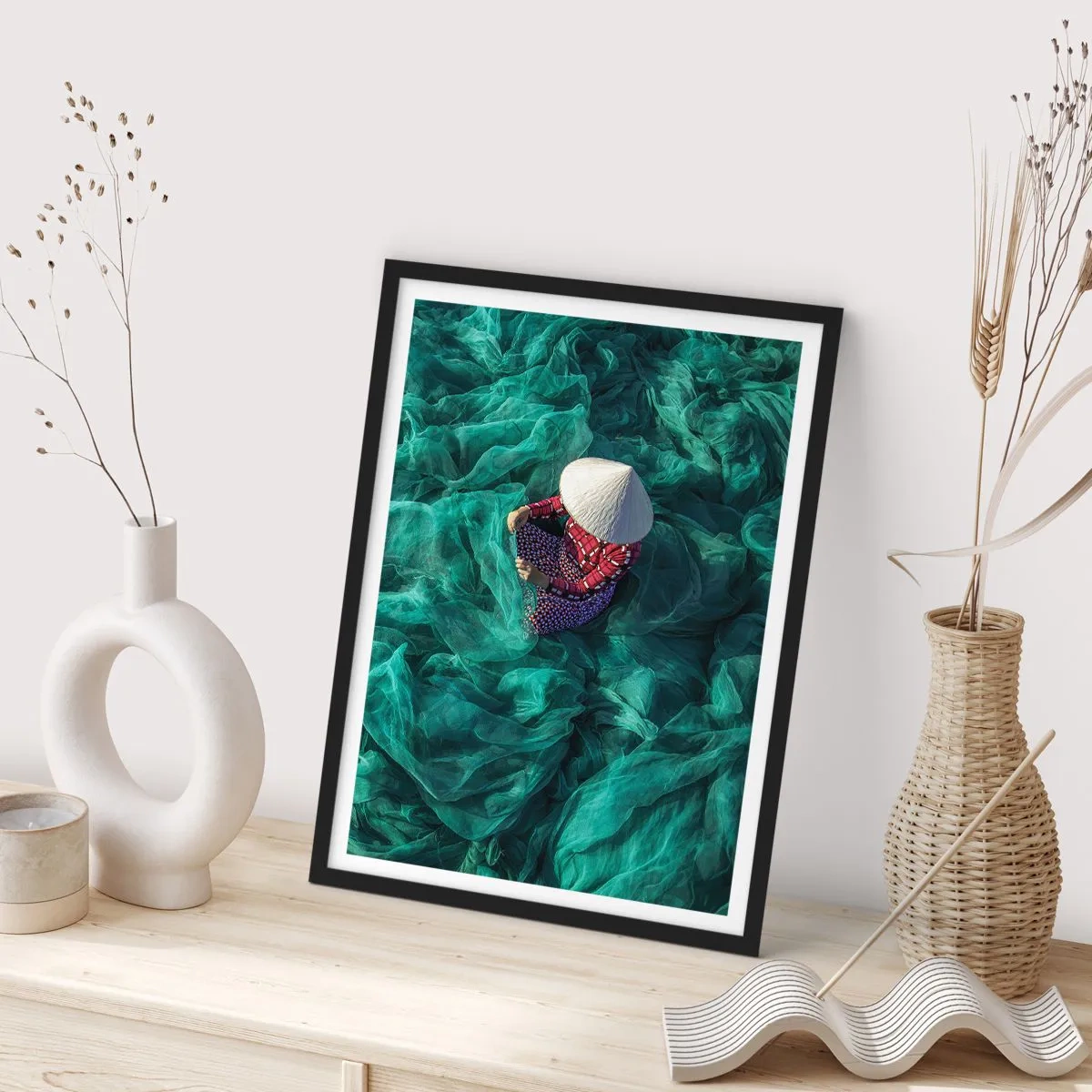 Plakat w czarnej ramie - Osoba w kapeluszu wśród zielonych sieci rybackich - 50x70cm - W morzu sieci - Nowoczesna dekoracja ścienna do salonu i sypialni ARTTOR