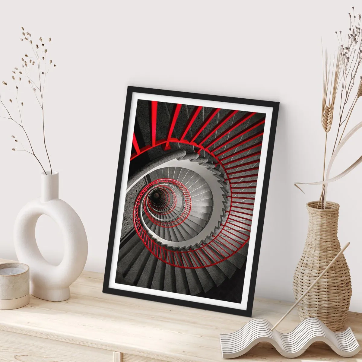 Plakat w czarnej ramie - Kręcone schody w czarno-białej tonacji z czerwonymi poręczami - 50x70cm - Zabawy architektury - Nowoczesna dekoracja ścienna do salonu i sypialni ARTTOR