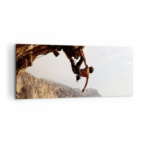 Obraz na płótnie - Wspinacz na stromym klifie w górach w promieniach słońca - 120x50cm - Świat skurczony w garści na obrywie głazu - Nowoczesna dekoracja ścienna do salonu i sypialni ARTTOR