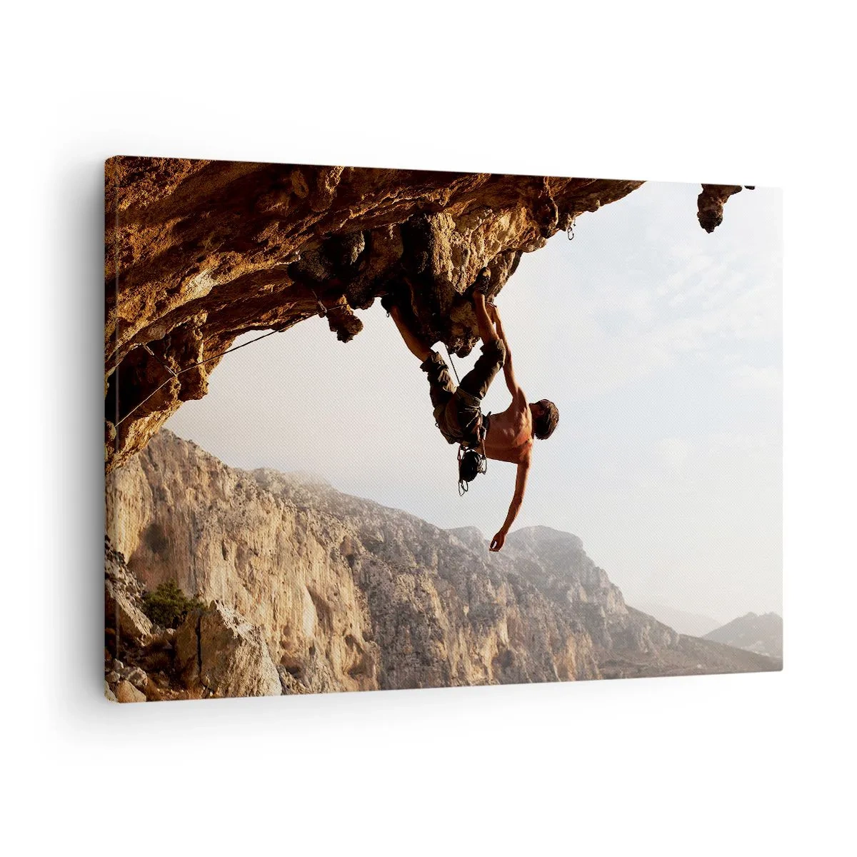 Obraz na płótnie - Wspinacz na stromym klifie w górach w promieniach słońca - 70x50cm - Świat skurczony w garści na obrywie głazu - Nowoczesna dekoracja ścienna do salonu i sypialni ARTTOR