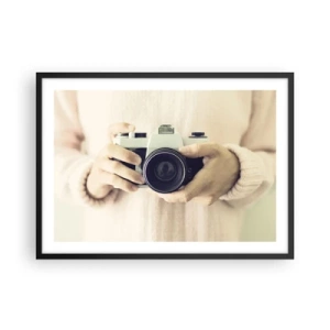 Plakat w czarnej ramie - Retro aparat fotograficzny trzymany w dłoniach na jasnym tle - 70x50cm - By widzieć więcej… - Nowoczesna dekoracja ścienna do salonu i sypialni ARTTOR