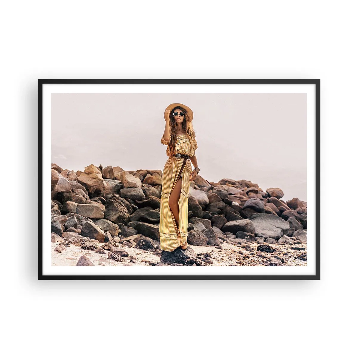 Plakat w czarnej ramie - Kobieta w stylu boho na tle kamienistej plaży - 100x70cm - Magia kamieni - Nowoczesna dekoracja ścienna do salonu i sypialni ARTTOR