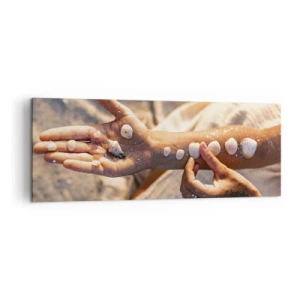 Obraz na płótnie - Dłonie z ułożonymi muszlami na tle piasku - 140x50cm - Piękno w zasięgu ręki - Nowoczesna dekoracja ścienna do salonu i sypialni ARTTOR