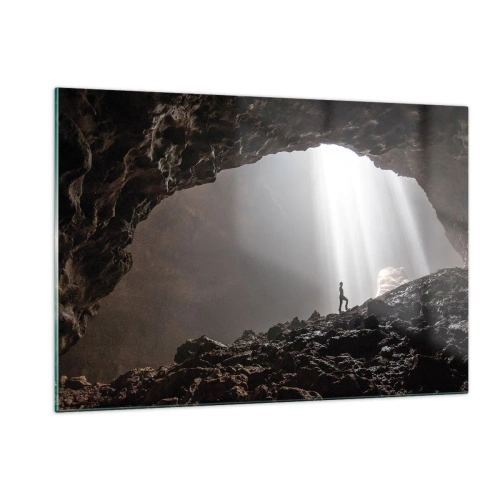 Obraz na szkle - Postać w jaskini oświetlonej promieniami światła, otoczonej przez ciemne skały - 120x80cm - Świetlista grota - Nowoczesna dekoracja ścienna do salonu, kuchni i sypialni ARTTOR