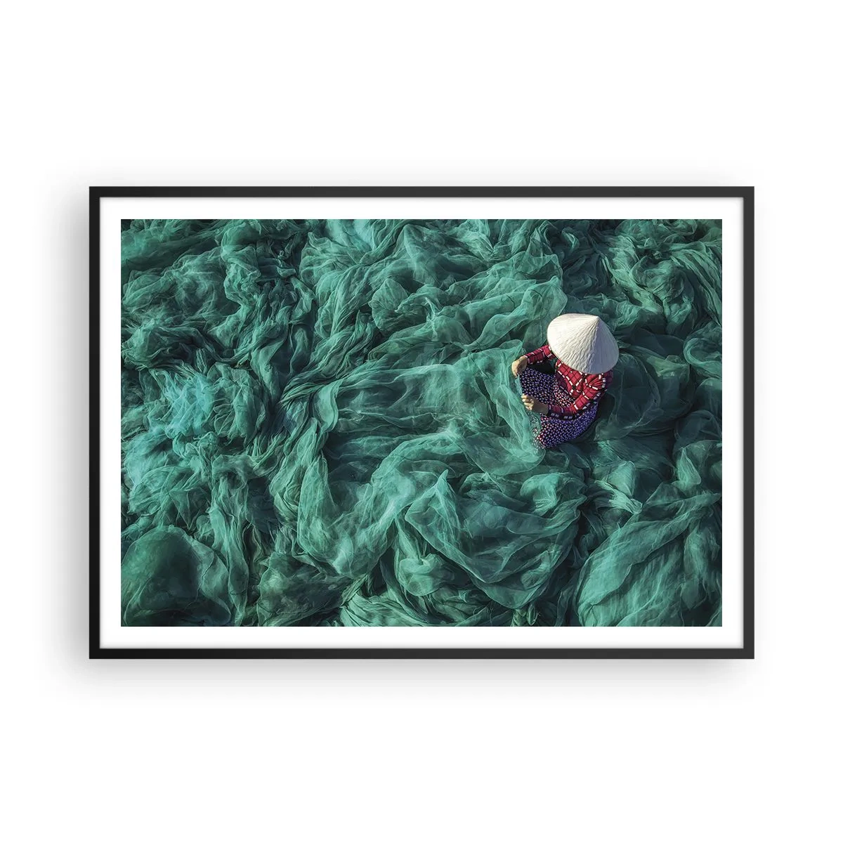 Plakat w czarnej ramie - Osoba z kapeluszem wśród zielonych sieci rybackich - 100x70cm - W morzu sieci - Nowoczesna dekoracja ścienna do salonu i sypialni ARTTOR
