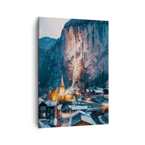 Obraz na płótnie - Zimowa wioska u podnóża gór z podświetlonym wodospadem - 50x70cm - Świetlisty duch zimy - Nowoczesna dekoracja ścienna do salonu, kuchni i sypialni ARTTOR