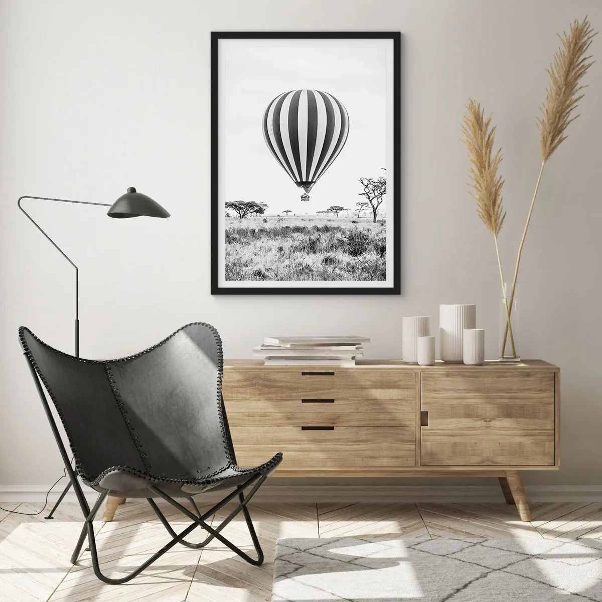 Plakat w czarnej ramie - Balon na gorące powietrze unoszący się nad sawanną w czarno-białym ujęciu - 50x70cm - Nad sawanną - Nowoczesna dekoracja ścienna do salonu i sypialni ARTTOR