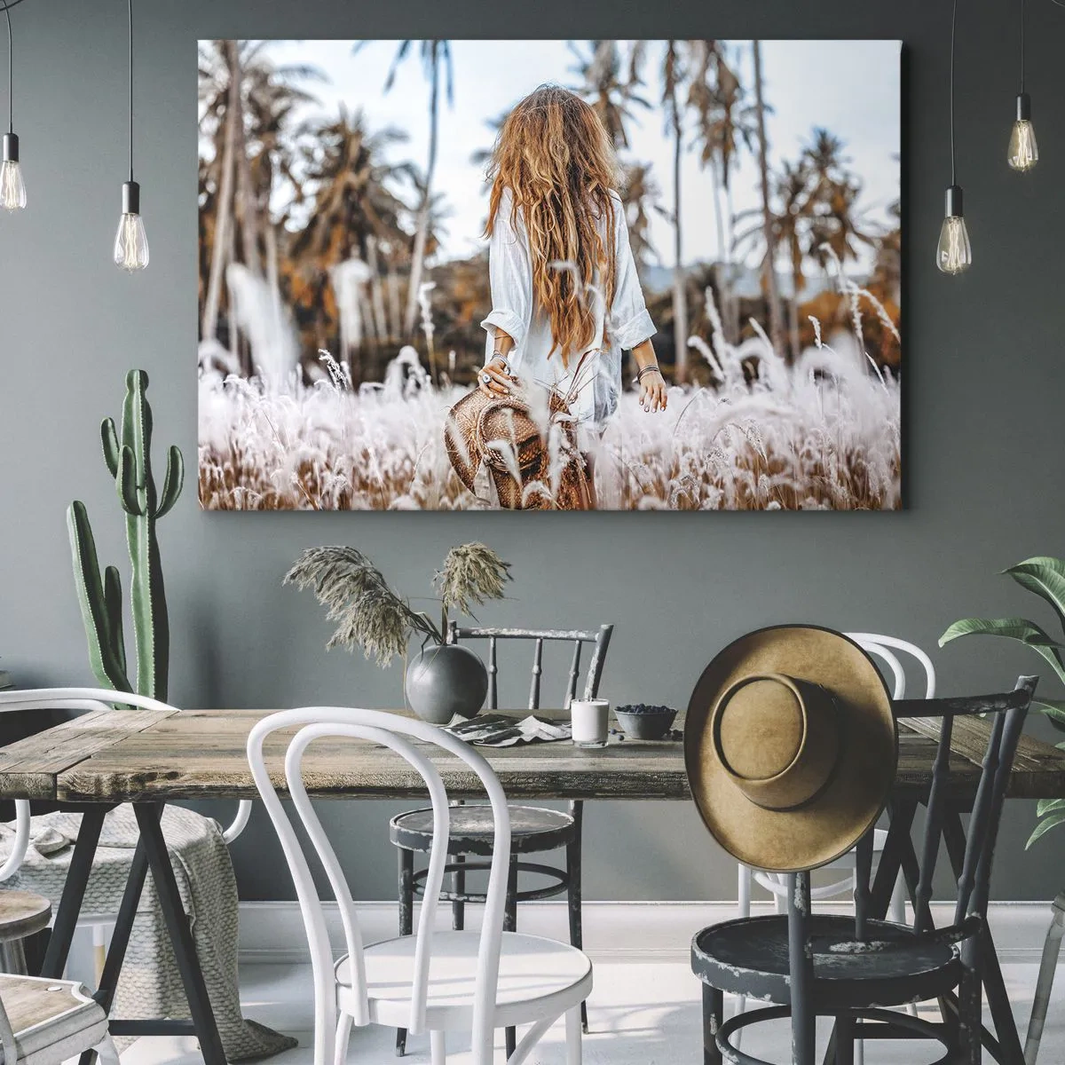 Obraz na płótnie - Kobieta w polu traw z palmami w tle o zachodzie słońca - 70x50cm - Zrodzona z puchu traw - Nowoczesna dekoracja ścienna do salonu i sypialni ARTTOR