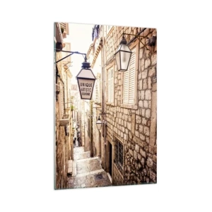 Obraz na szkle - Wąska, kamienna uliczka z latarniami i szyldem w klimacie śródziemnomorskim - 80x120cm - Urokliwy zaułek - Nowoczesna dekoracja ścienna do salonu i sypialni ARTTOR