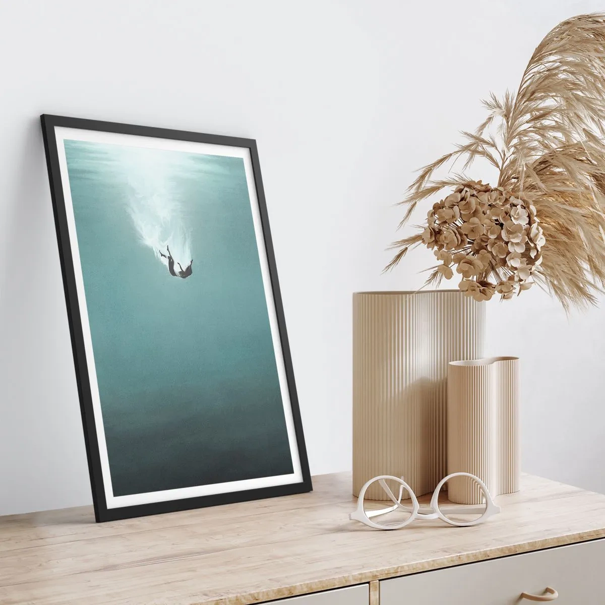 Plakat w czarnej ramie - Sylwetka człowieka opadającego w głębię wody - 50x70cm - W objęciach oceanu - Nowoczesna dekoracja ścienna do salonu i sypialni ARTTOR