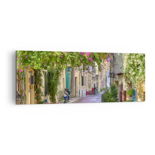 Obraz na płótnie - Urokliwa uliczka z kwitnącymi pnączami i kawiarnianymi stolikami - 140x50cm - Kwitnący zaułek - Nowoczesna dekoracja ścienna do salonu i sypialni ARTTOR