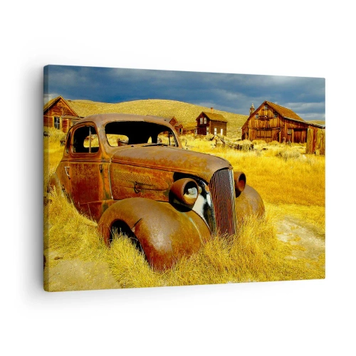 Obraz na płótnie - Stary zardzewiały samochód na tle opuszczonych drewnianych chat - 70x50cm - Zasłużony odpoczynek - Nowoczesna dekoracja ścienna do salonu i sypialni ARTTOR