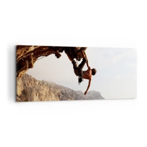 Obraz na płótnie - Wspinacz na stromym klifie w górach w promieniach słońca - 120x50cm - Świat skurczony w garści na obrywie głazu - Nowoczesna dekoracja ścienna do salonu i sypialni ARTTOR