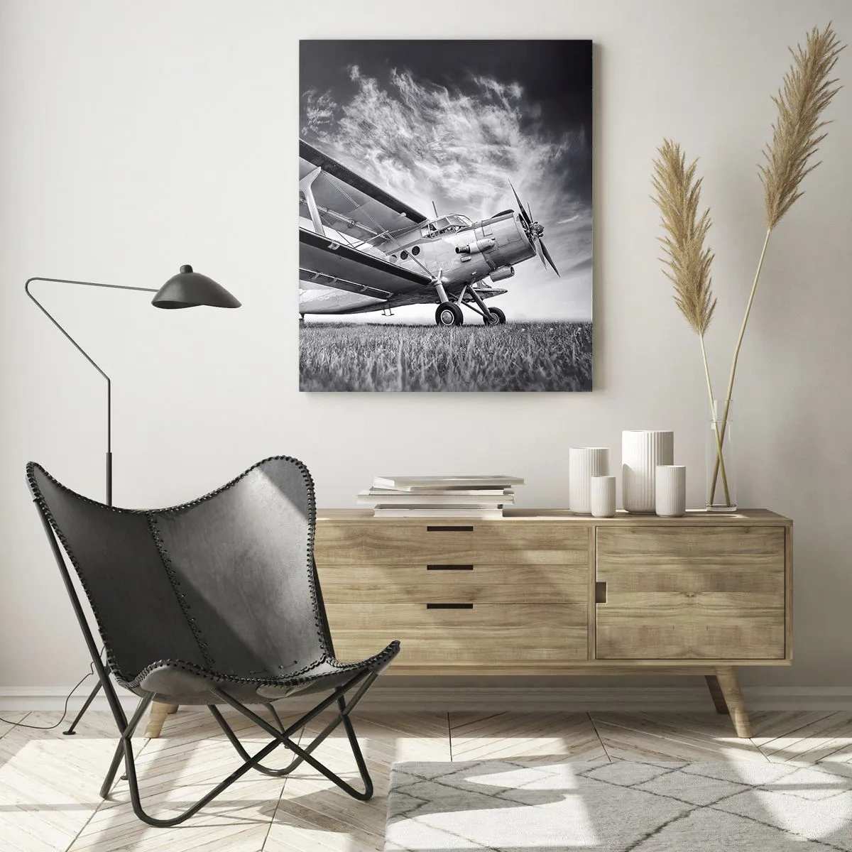 Obraz na szkle - Czarno-biała fotografia samolotu na tle dramatycznego nieba - 50x70cm - Skrzydlaty wędrowiec - Nowoczesna dekoracja ścienna do salonu, kuchni i sypialni ARTTOR