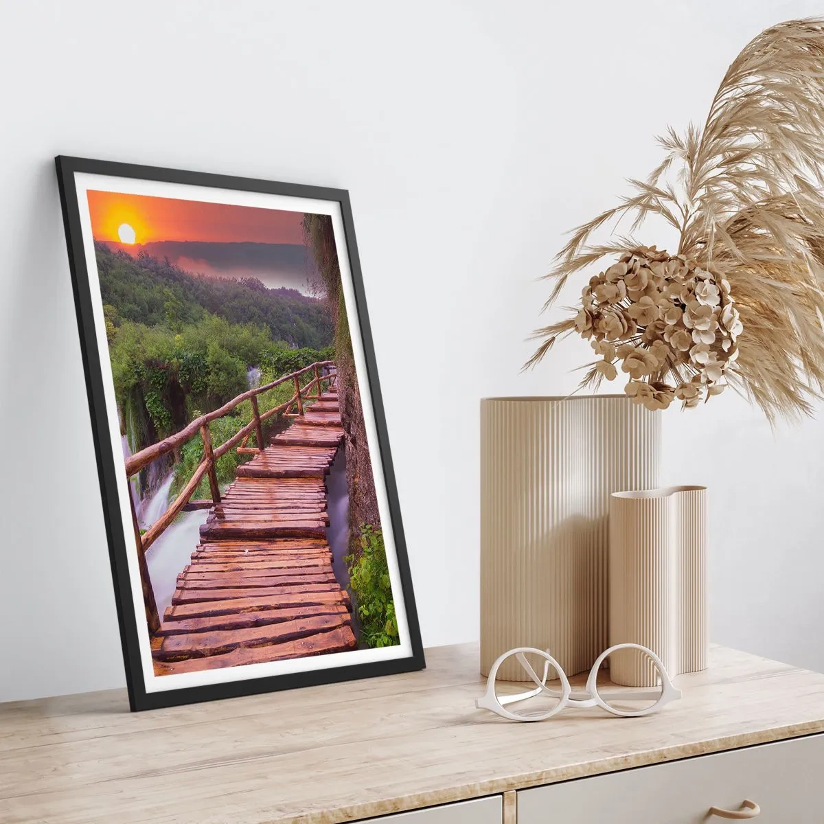 Plakat w czarnej ramie - Drewniany mostek wśród zieleni i zachodzącego słońca - 50x70cm - Piękno nie do uwierzenia - Nowoczesna dekoracja ścienna do salonu i sypialni ARTTOR