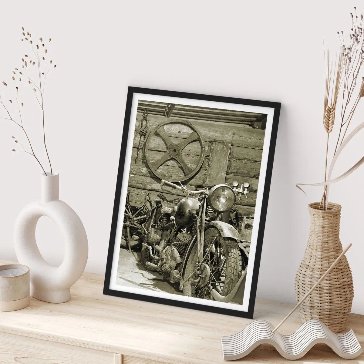 Plakat w czarnej ramie - Stary motocykl w drewnianej szopie z kołem w tle - 50x70cm - W szopie wuja Władka - Nowoczesna dekoracja ścienna do salonu i sypialni ARTTOR