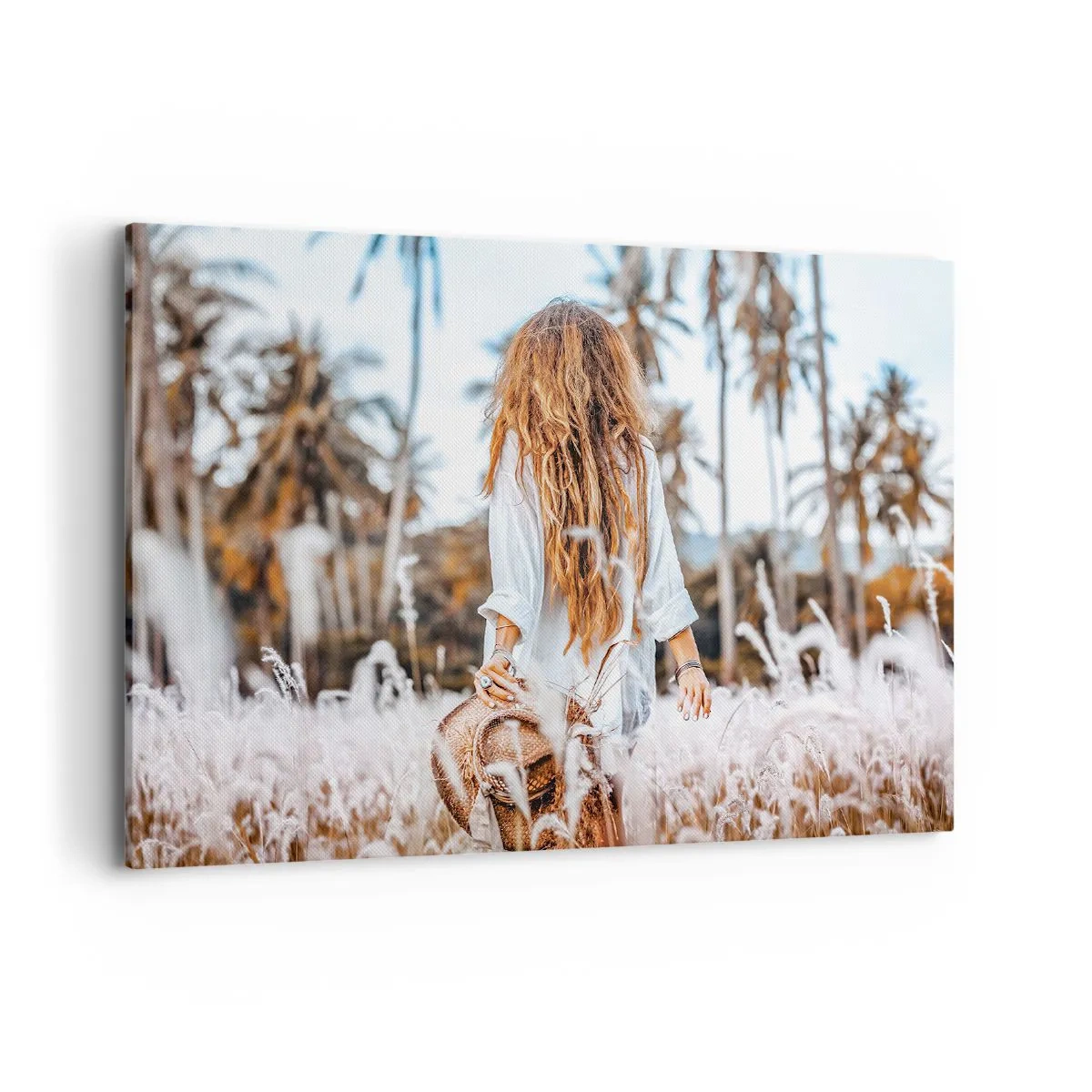 Obraz na płótnie - Kobieta w polu traw z palmami w tle o zachodzie słońca - 100x70cm - Zrodzona z puchu traw - Nowoczesna dekoracja ścienna do salonu, kuchni i sypialni ARTTOR