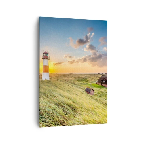 Obraz na płótnie - Latarnia morska na tle łąk i domów w promieniach słońca - 70x100cm - Między falami - Nowoczesna dekoracja ścienna do salonu i sypialni ARTTOR