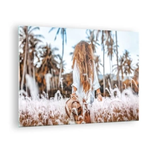 Obraz na szkle - Kobieta wśród traw z kapeluszem w ręku na tle palm - 70x50cm - Zrodzona z puchu traw - Nowoczesna dekoracja ścienna do salonu i sypialni ARTTOR