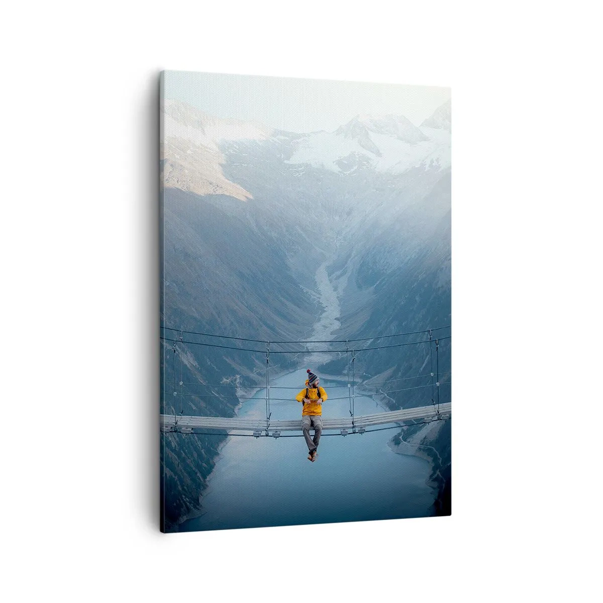Obraz na płótnie - Osoba w żółtej kurtce siedząca na wiszącym moście nad górskim jeziorem - 50x70cm - Zachwycony w zawieszeniu - Nowoczesna dekoracja ścienna do salonu, kuchni i sypialni ARTTOR