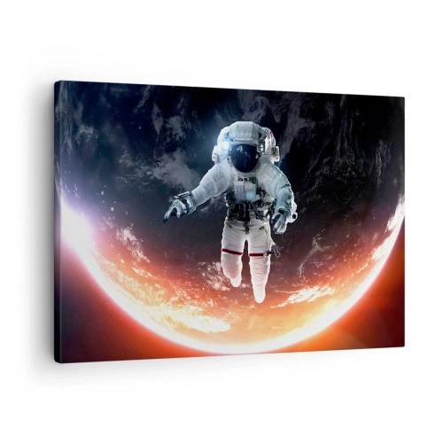 Obraz na płótnie - Astronauta unoszący się nad Ziemią oświetloną słońcem - 70x50cm - Mogę zostać jeszcze chwilę? - Nowoczesna dekoracja ścienna do salonu i sypialni ARTTOR