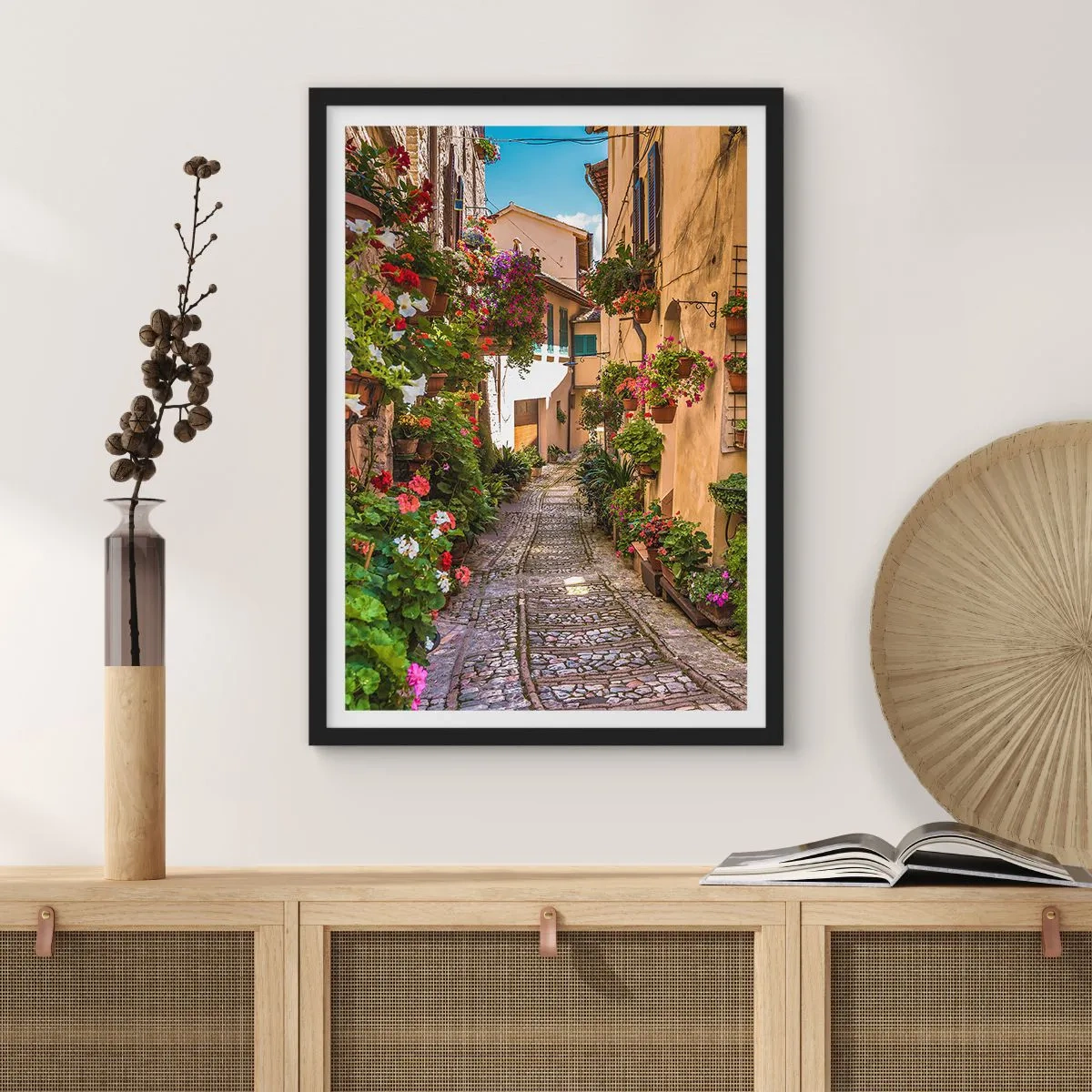 Plakat w czarnej ramie - Urocza uliczka z kwiatami i brukowaną ścieżką w słoneczny dzień - 50x70cm - Włoski zaułek - Nowoczesna dekoracja ścienna do salonu i sypialni ARTTOR