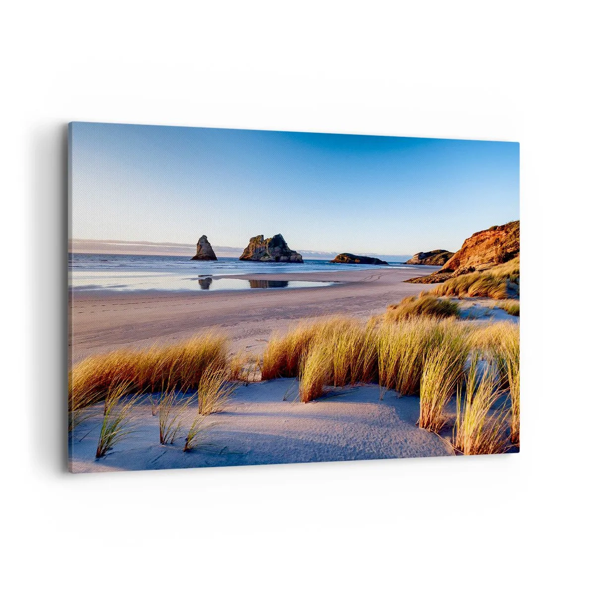 Obraz na płótnie - Malownicza plaża z widokiem na skały i morze o zachodzie słońca - 100x70cm - Dla poszukiwaczy spokoju - Nowoczesna dekoracja ścienna do salonu, kuchni i sypialni ARTTOR