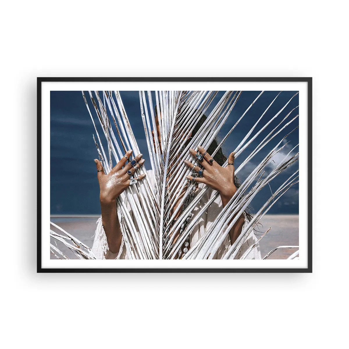 Plakat w czarnej ramie - Kobieta ukryta za palmowymi liśćmi z pierścieniami na dłoniach - 100x70cm - Dziewczyna szamana? - Nowoczesna dekoracja ścienna do salonu i sypialni ARTTOR