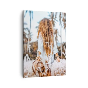 Obraz na płótnie - Kobieta z długimi włosami spacerująca po polu traw w otoczeniu palm - 50x70cm - Zrodzona z puchu traw - Nowoczesna dekoracja ścienna do salonu, kuchni i sypialni ARTTOR