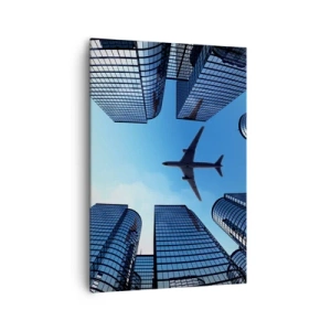 Obraz na płótnie - Samolot lecący nad nowoczesnymi wieżowcami w centrum miasta - 70x100cm - Widok ze szklanego wąwozu - Nowoczesna dekoracja ścienna do salonu i sypialni ARTTOR