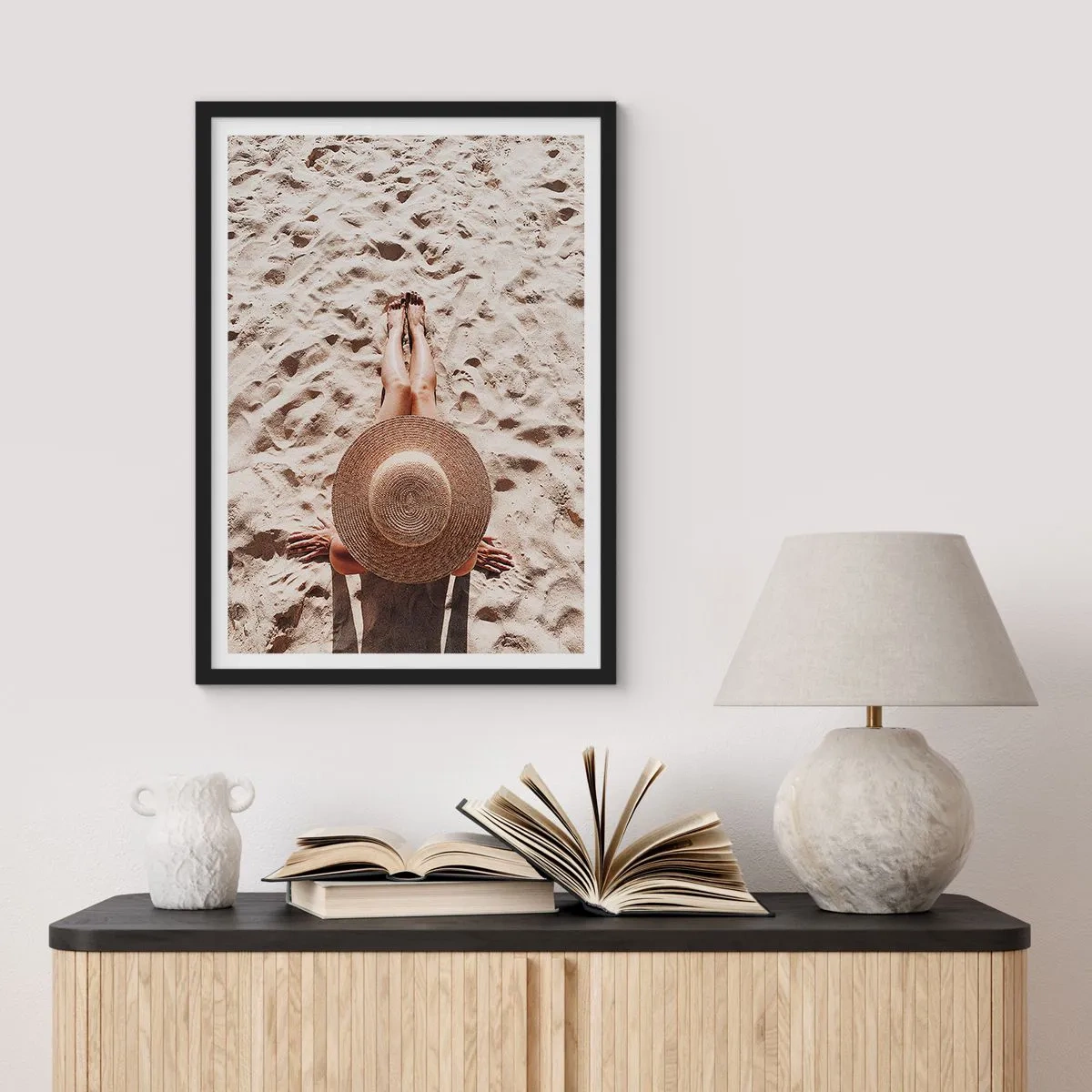 Plakat w czarnej ramie - Osoba opalająca się na plaży, widok z góry z dużym kapeluszem na tle piasku - 50x70cm - Wymarzony czas - Nowoczesna dekoracja ścienna do salonu i sypialni ARTTOR