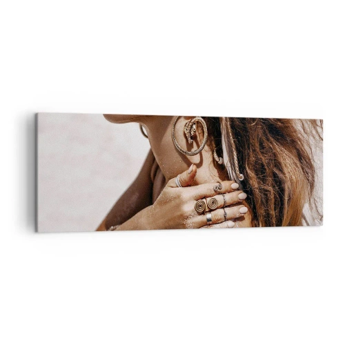 Obraz na płótnie - Stylowa kobieta z biżuterią na tle jasnego piasku - 140x50cm - Królowa dzikiej plaży - Nowoczesna dekoracja ścienna do salonu i sypialni ARTTOR