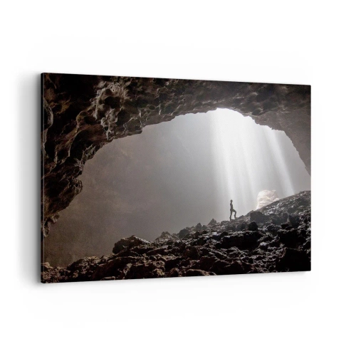 Obraz na płótnie - Postać w jaskini oświetlonej promieniami światła - 100x70cm - Świetlista grota - Nowoczesna dekoracja ścienna do salonu, kuchni i sypialni ARTTOR