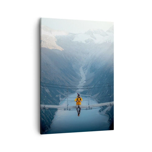 Obraz na płótnie - Osoba w żółtej kurtce siedząca na wiszącym moście nad górskim jeziorem - 50x70cm - Zachwycony w zawieszeniu - Nowoczesna dekoracja ścienna do salonu, kuchni i sypialni ARTTOR