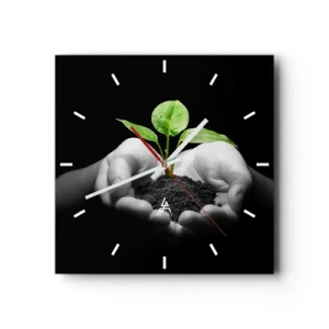Zegar ścienny - Dłonie trzymające zieloną roślinę na czarnym tle - 30x30cm - Kocham naturę, chronię ją - Nowoczesna dekoracja ścienna do salonu i sypialni ARTTOR