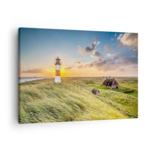 Obraz na płótnie - Latarnia morska na tle łąk i domów w promieniach słońca - 70x50cm - Między falami - Nowoczesna dekoracja ścienna do salonu i sypialni ARTTOR