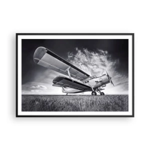 Plakat w czarnej ramie - Samolot na tle dramatycznego nieba w czerni i bieli - 100x70cm - Skrzydlaty wędrowiec - Nowoczesna dekoracja ścienna do salonu i sypialni ARTTOR