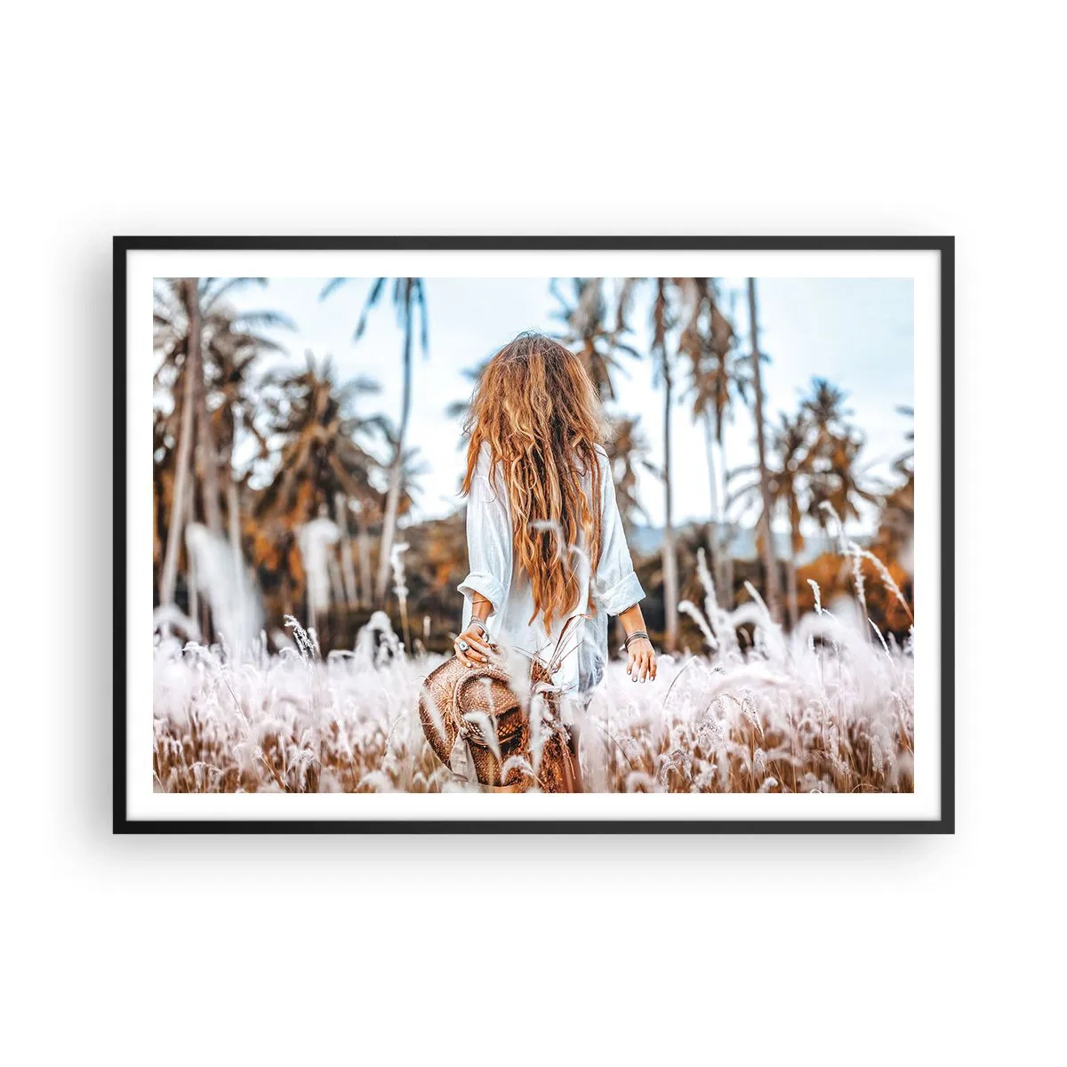 Plakat w czarnej ramie - Kobieta w polu traw z palmami w tle o zachodzie słońca - 100x70cm - Zrodzona z puchu traw - Nowoczesna dekoracja ścienna do salonu i sypialni ARTTOR