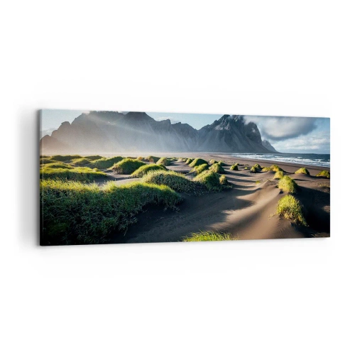 Obraz na płótnie - Zielone wydmy z górskim tłem pod błękitnym niebem - 120x50cm - Harmonia żywiołów - Nowoczesna dekoracja ścienna do salonu i sypialni ARTTOR