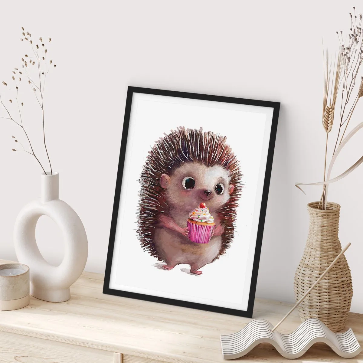 Plakat w czarnej ramie - Święto jest co dzień - Uroczy jeżyk trzymający kolorową babeczkę - 50x70cm