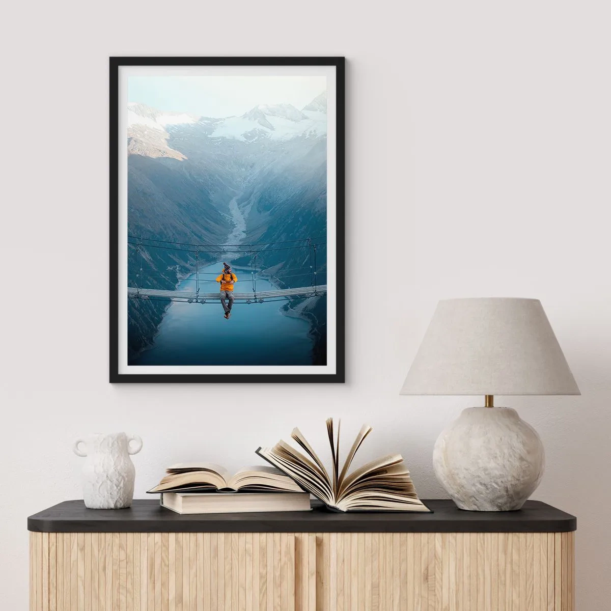 Plakat w czarnej ramie - Osoba w żółtej kurtce siedząca na wiszącym moście nad doliną - 50x70cm - Zachwycony w zawieszeniu - Nowoczesna dekoracja ścienna do salonu i sypialni ARTTOR