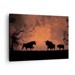 Obraz na płótnie - Sylwetki byków na tle pomarańczowego nieba o zachodzie słońca - 70x50cm - Dramatyczny spektakl natury - Nowoczesna dekoracja ścienna do salonu i sypialni ARTTOR