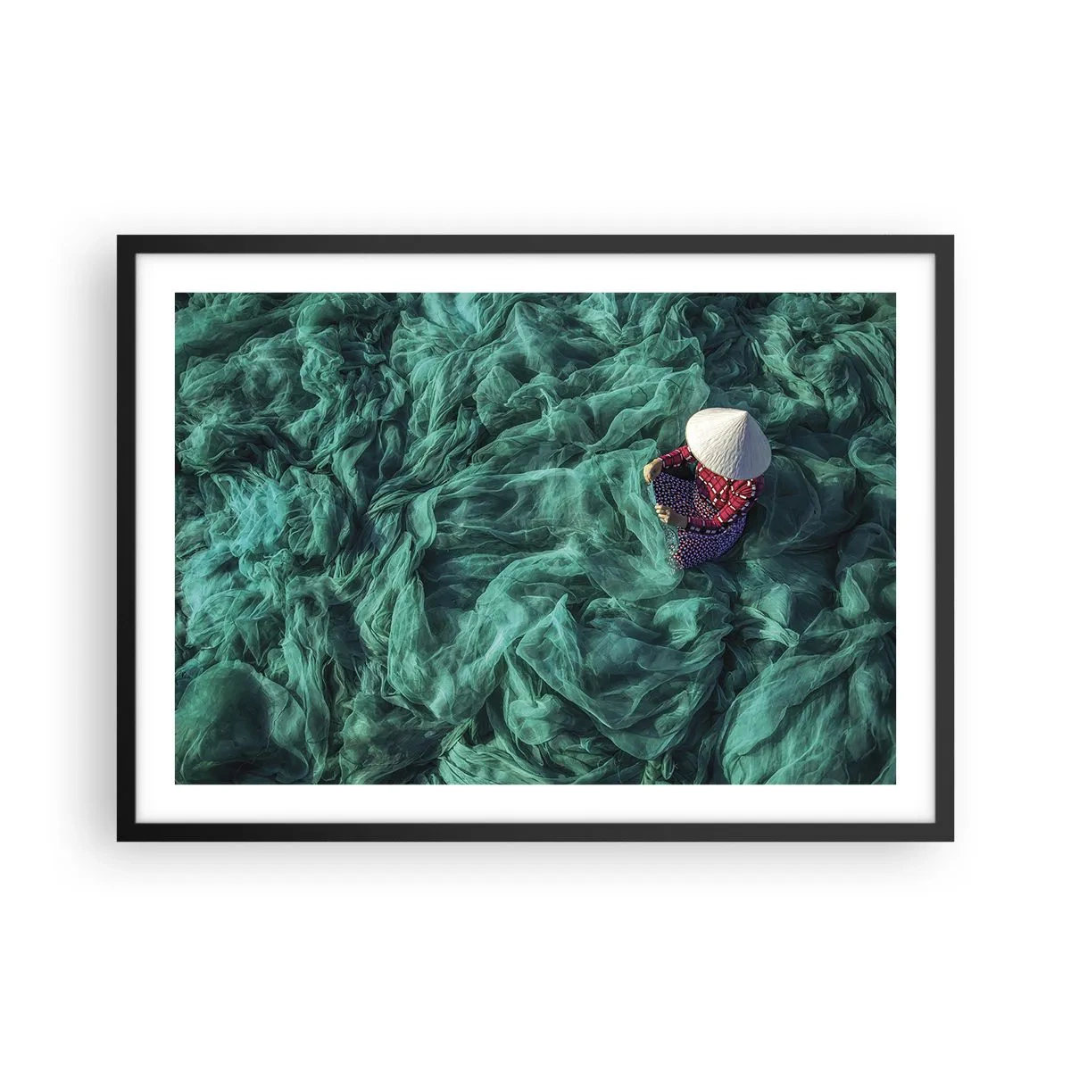 Plakat w czarnej ramie - Osoba z kapeluszem wśród zielonych sieci rybackich - 70x50cm - W morzu sieci - Nowoczesna dekoracja ścienna do salonu i sypialni ARTTOR